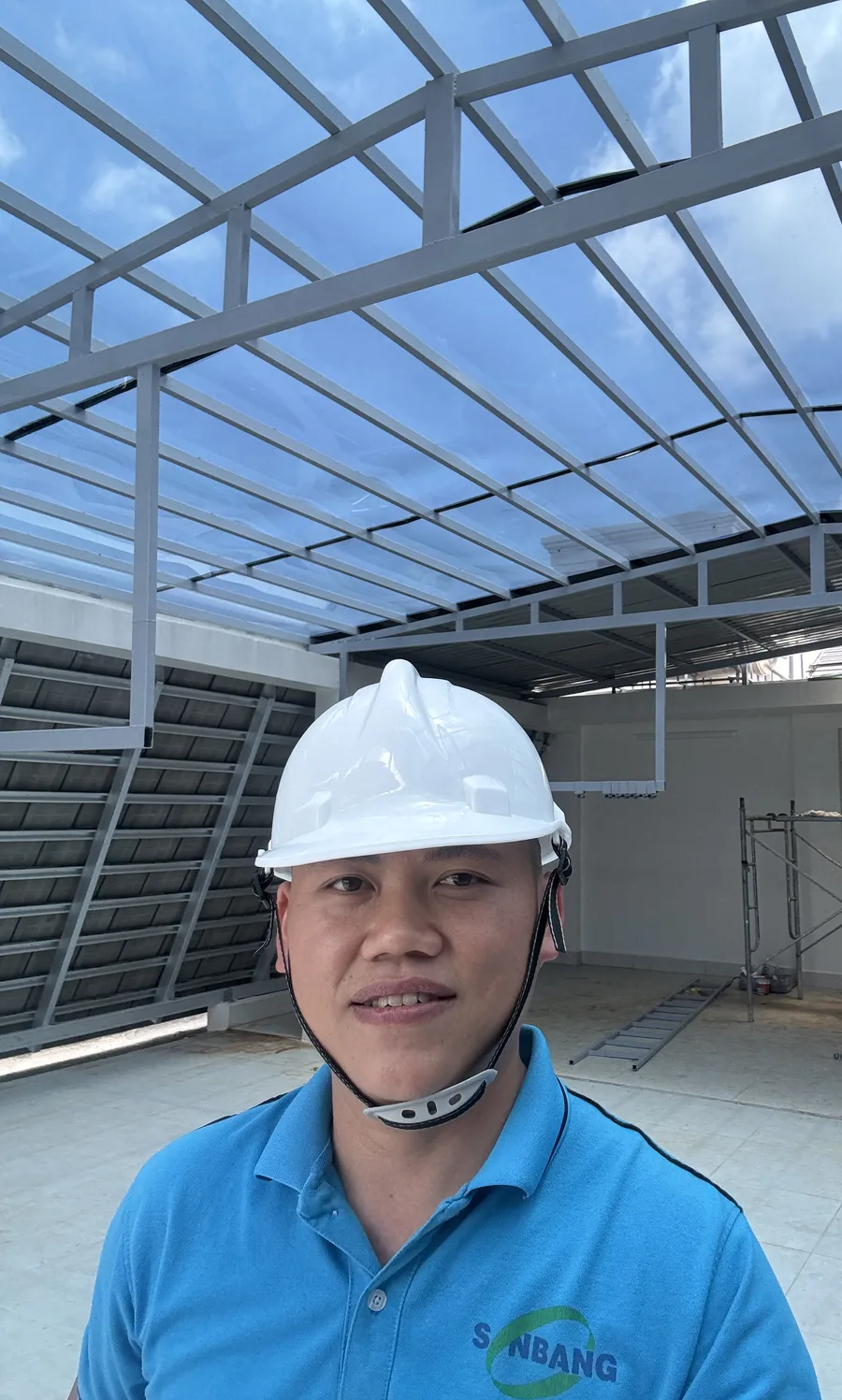 Founder Đinh Bảo Phú in a hard hat under a newly finished skylight roof at a hotel project in Long An